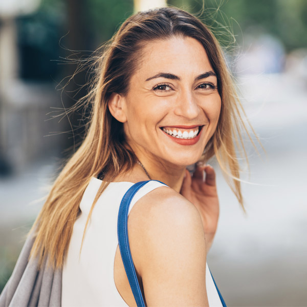 woman smiling while walking outside