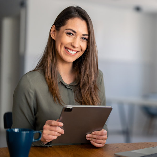 beautiful woman smiling while holding ipad